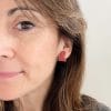 Pendiente corazón pequeño rojo puesto, pegado a la oreja