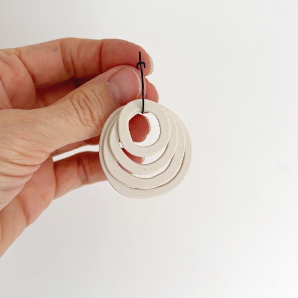 Pendientes Rosa en color Blanco sujetados en la mano